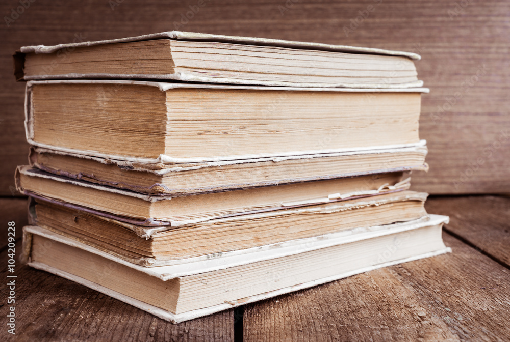 Stack of old books on wooden background