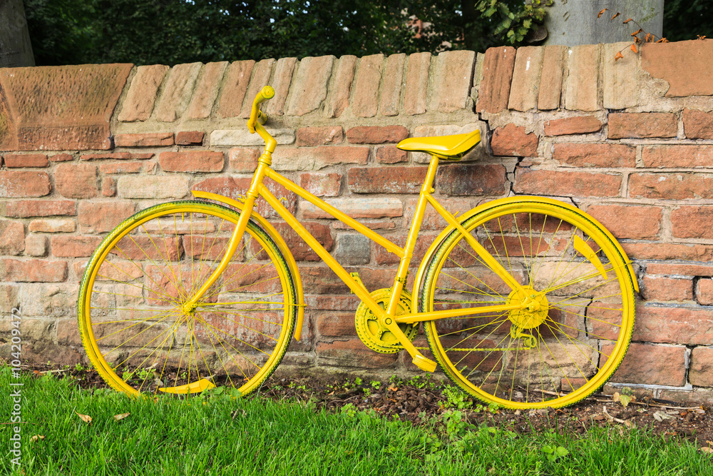 Obraz premium Yellow Bicycle. One of a number of yellow bicycles lining the route of the 2015 Tour of Britain cycle race through the Eden Valley in Cumbria, England.