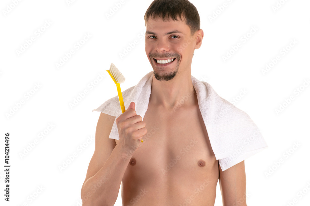 smiling adult naked man with big bright yellow toothbrush in hand and white towel on his shoulders looking at camera smiling adult naked man with big bright yellow toothbrush in hand and white towel on his shoulders looking at camera
