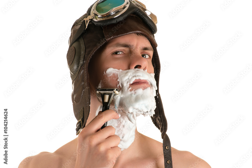 portrait of a man shaving with shaving foam on his face in a flight
