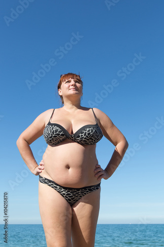 Fotografie Woman arms akimbo posing against the sea