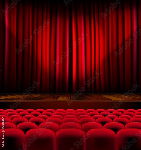 Theater auditorium with rows of seats and stage with curtain