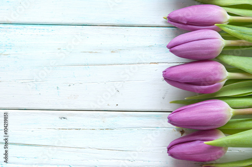 Purple tulips on wooden bac...