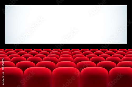 Cinema auditorium with rows of red seats and blank screen
