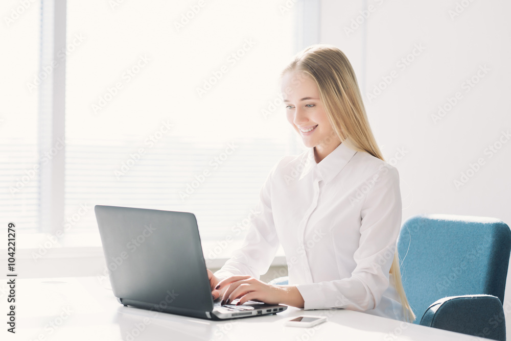 Young businesswoman typing and looking at laptop in office Young businesswoman typing and looking at laptop in office