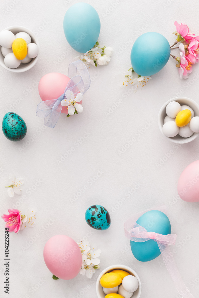 Easter eggs background. Various pastel colored Easter eggs, candies and decorations.