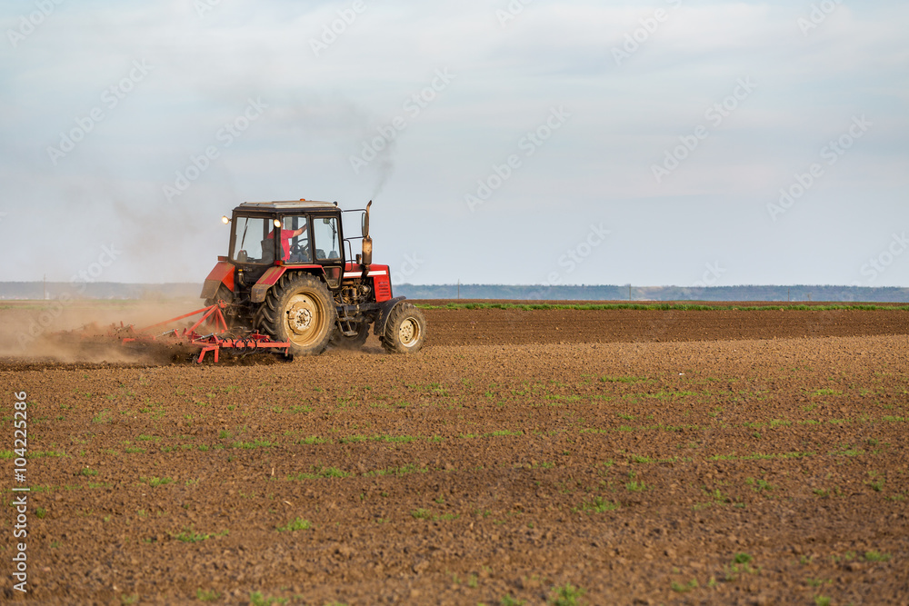 Tractor cultivating field at spring Tractor cultivating field at spring