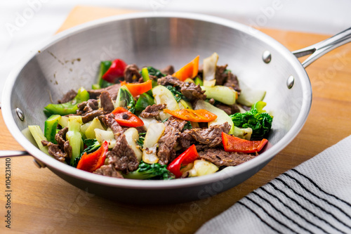 Beef Stir Fry in a wok. Healthy vegetable & beef stir-fry. Made with flank steak, peppers, onions and bok choy stir fried in an asian wok.