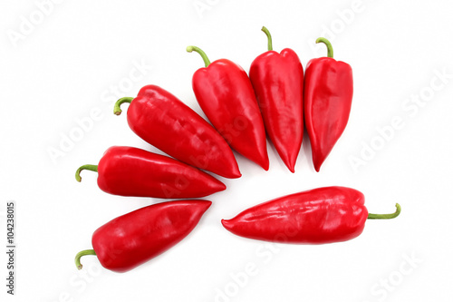 seven bright red sweet peppers on a white background