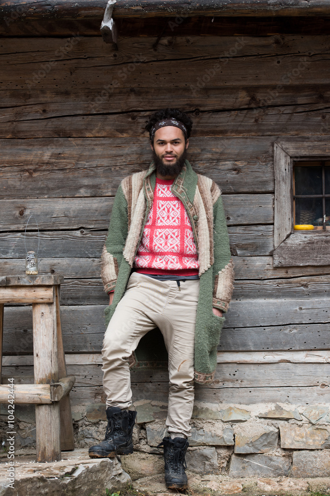 portrait of young hipster in front of wooden house portrait of young hipster in front of wooden house