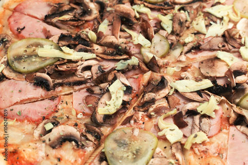 Pizza with ham, mushrooms and vegetables close up