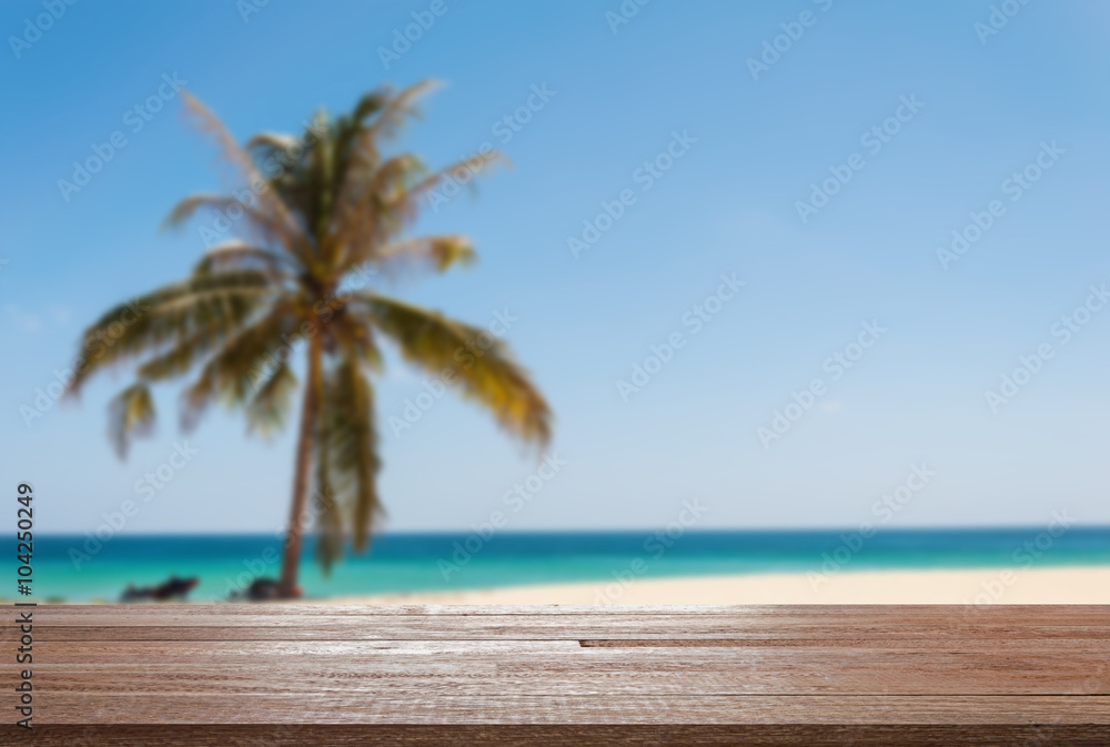 Wood table top on blurred blue sea and white sand beach