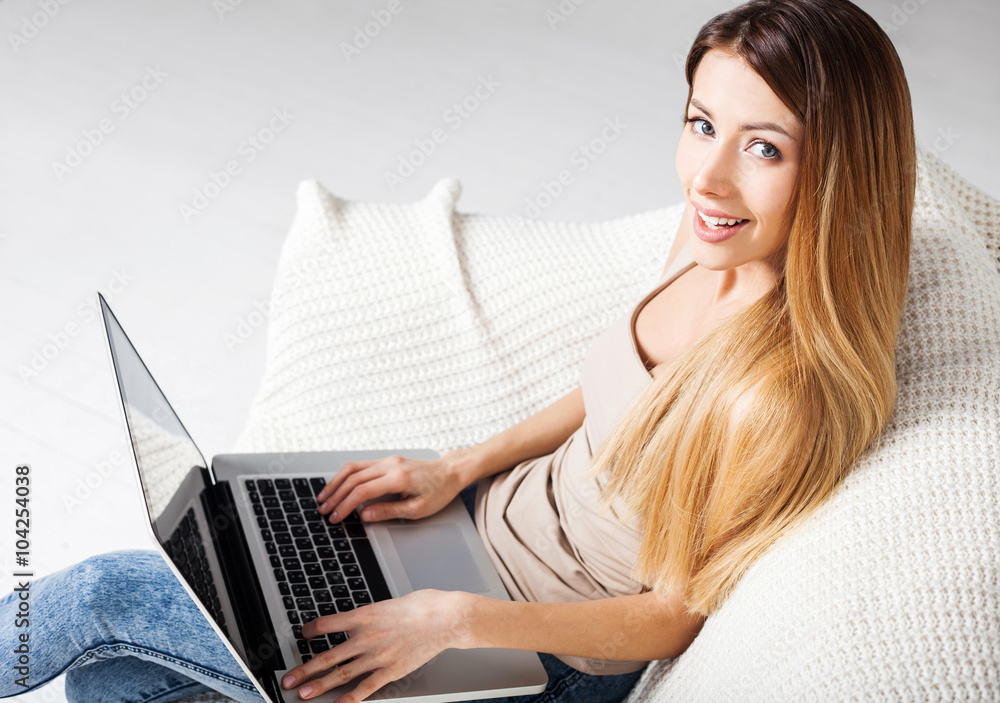 Young beautiful woman using a laptop computer at home Young beautiful woman using a laptop computer at home