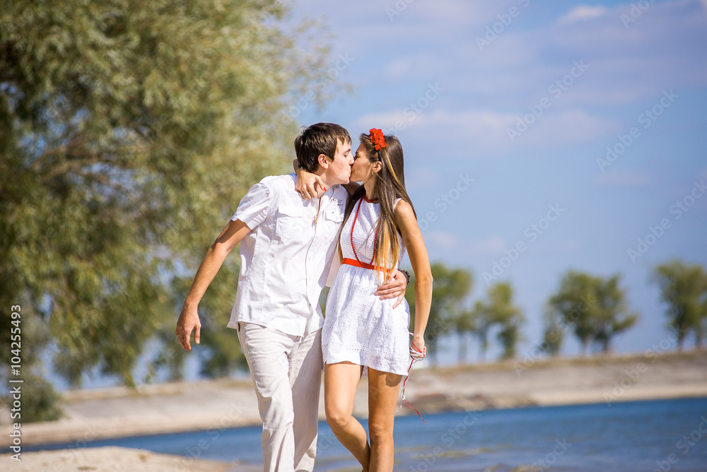 happy girl with the guy sitting on the beach in spring, summer. happy girl with the guy sitting on the beach in spring, summer.
