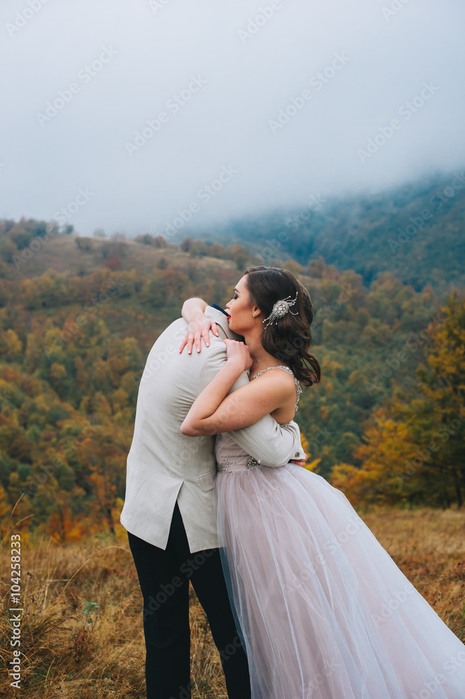 happy newly married couple posing in the mountains happy newly married couple posing in the mountains