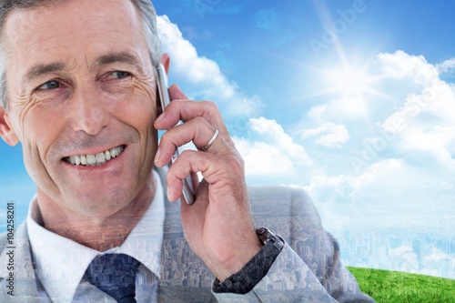 Composite image of buisnessman talking on mobile phone photo