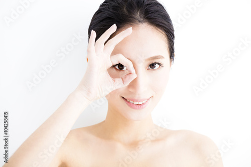 Closeup of young smiling woman eyes with gesture