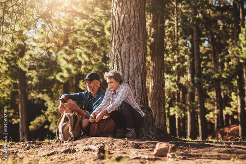 Mature couple under a tree with backpacks and compass © Jacob Lund
