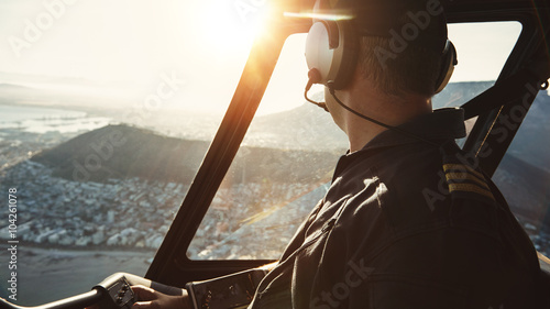Pilot flying a helicopter and looking outside the window