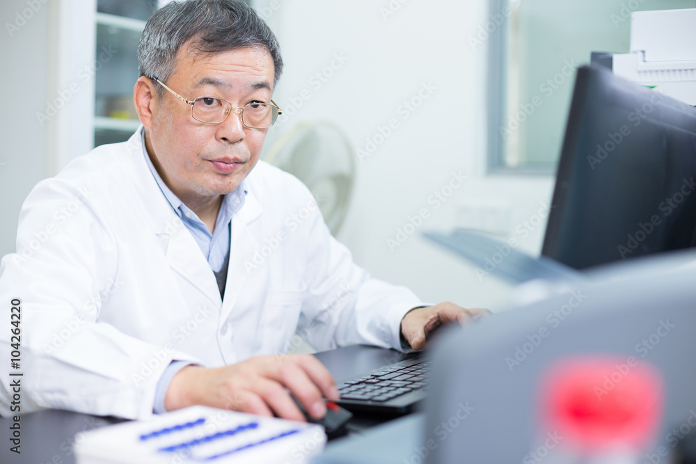 Asian old man analysises experimental data in lab
