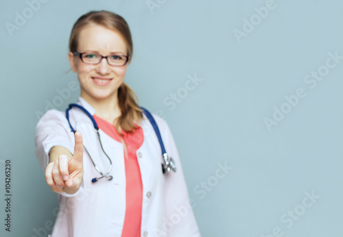    oncept - focus on the finger. Doctor pointing her finger up.
