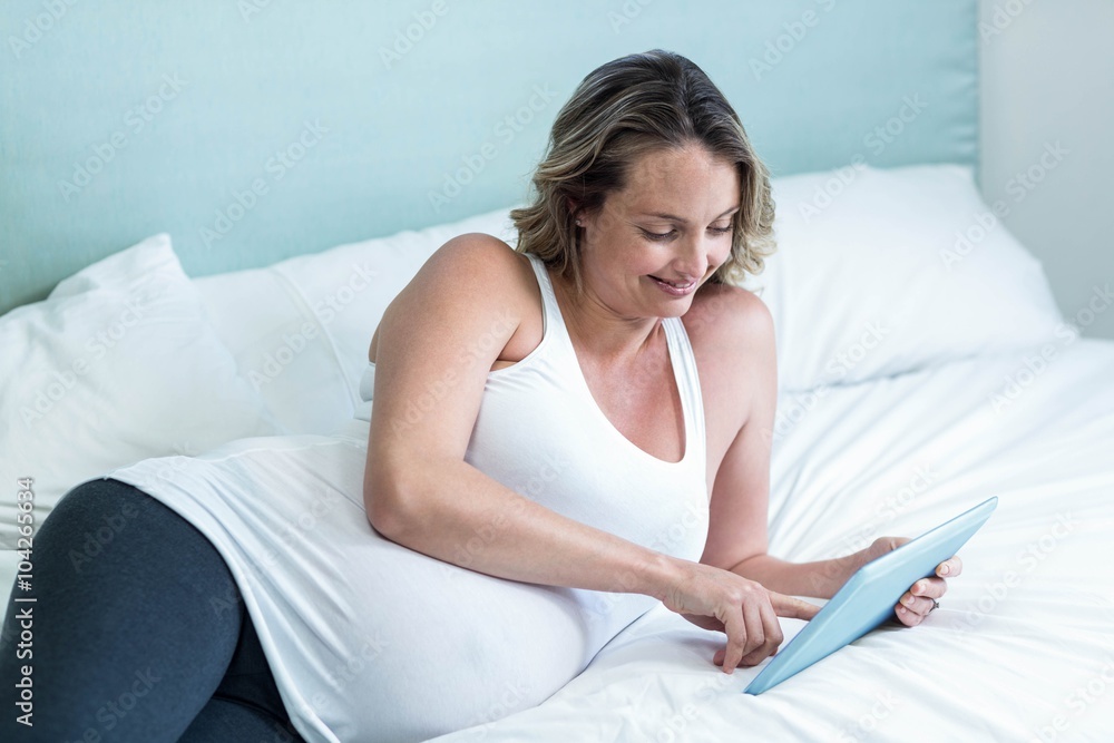 Pregnant woman using tablet computer Pregnant woman using tablet computer
