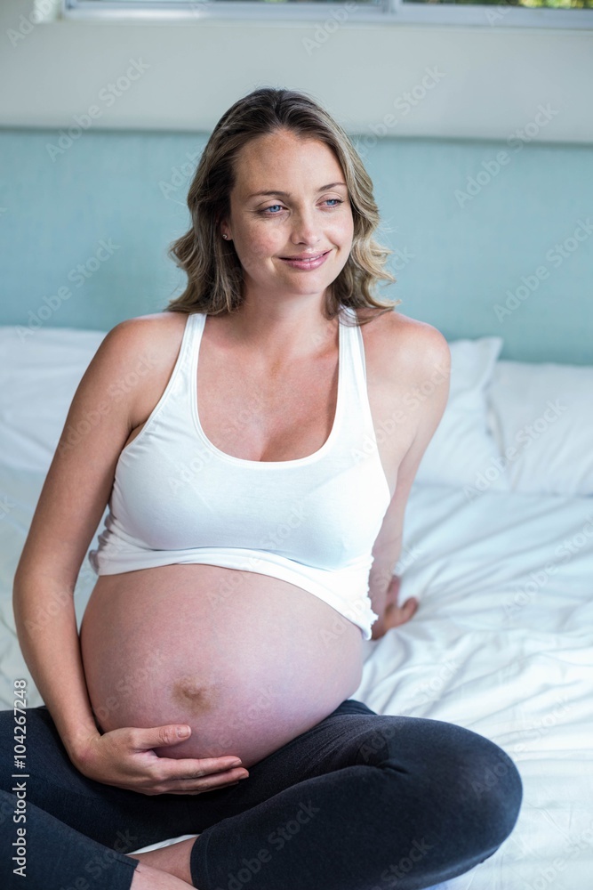 Pregnant woman resting on her bed
