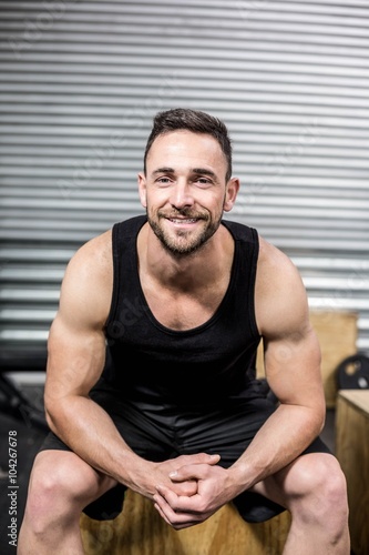 Fit man sitting on wooden box