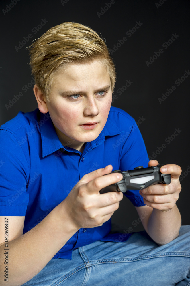 Serious teen holding video game controller Serious teen holding video game controller