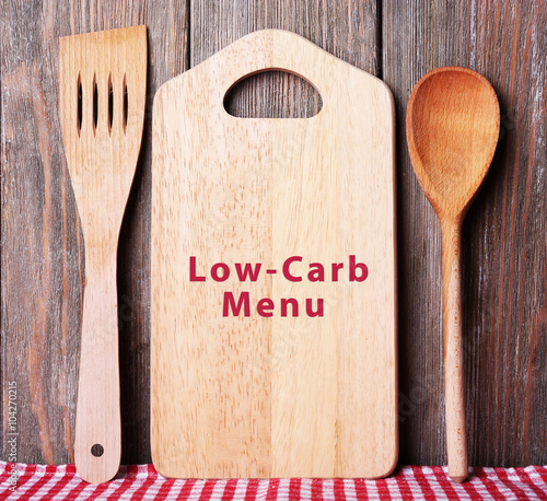 Cutting board with text Low-Carb Menu on wooden planks background