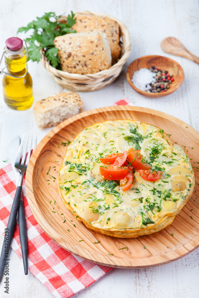 Omelet with potato from spain called tortilla de patatas on a white wooden background