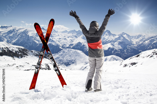 Pair of cross skis with woman skier, hands up