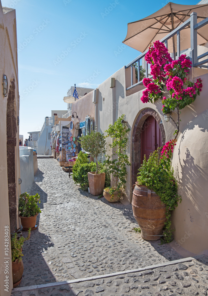 Fototapeta Santorini - ulica Oia z sklepami z pamiątkami i restauracjami.