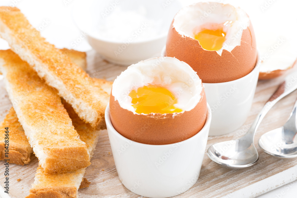 boiled eggs and toasts on wooden board, closeup, selective focus boiled eggs and toasts on wooden board, closeup, selective focus