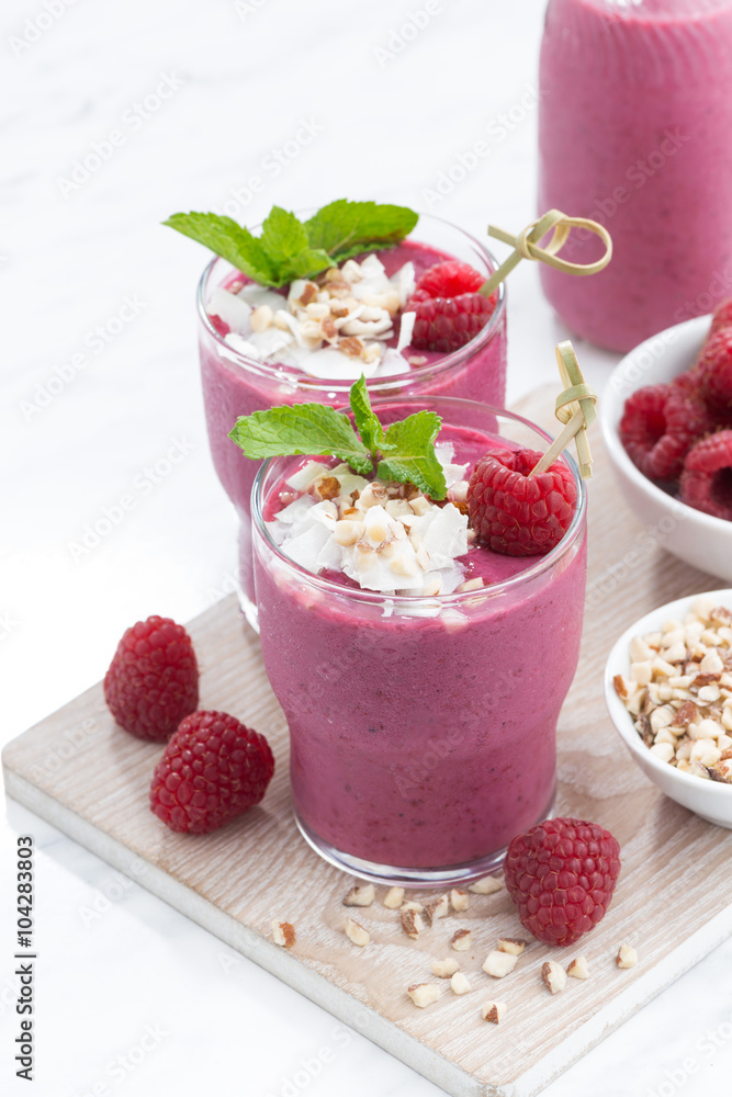 fresh berry smoothies with nuts on white board, vertical fresh berry smoothies with nuts on white board, vertical