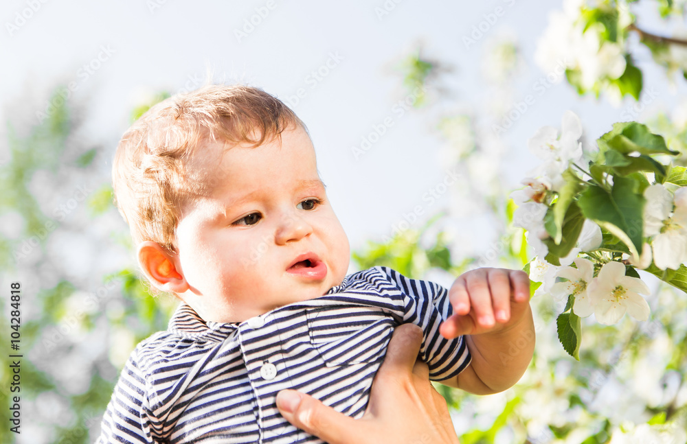 happy loving family with baby son in blooming spring garden. Mother holding baby. Spending time together outdoor. Mothers day holiday concept happy loving family with baby son in blooming spring garden. Mother holding baby. Spending time together outdoor. Mothers day holiday concept