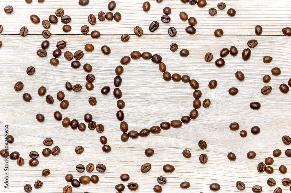 Heart made using coffee beans on a wooden background Heart made using coffee beans on a wooden background