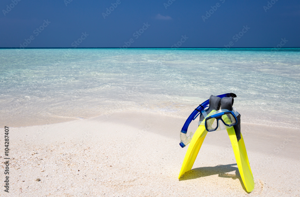 Taucherbrille und Flossen am Strand stehend Taucherbrille und Flossen am Strand stehend