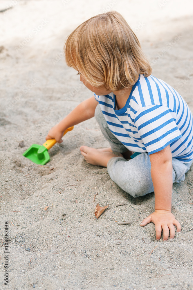 Toddler boy playing in the sandbox Toddler boy playing in the sandbox