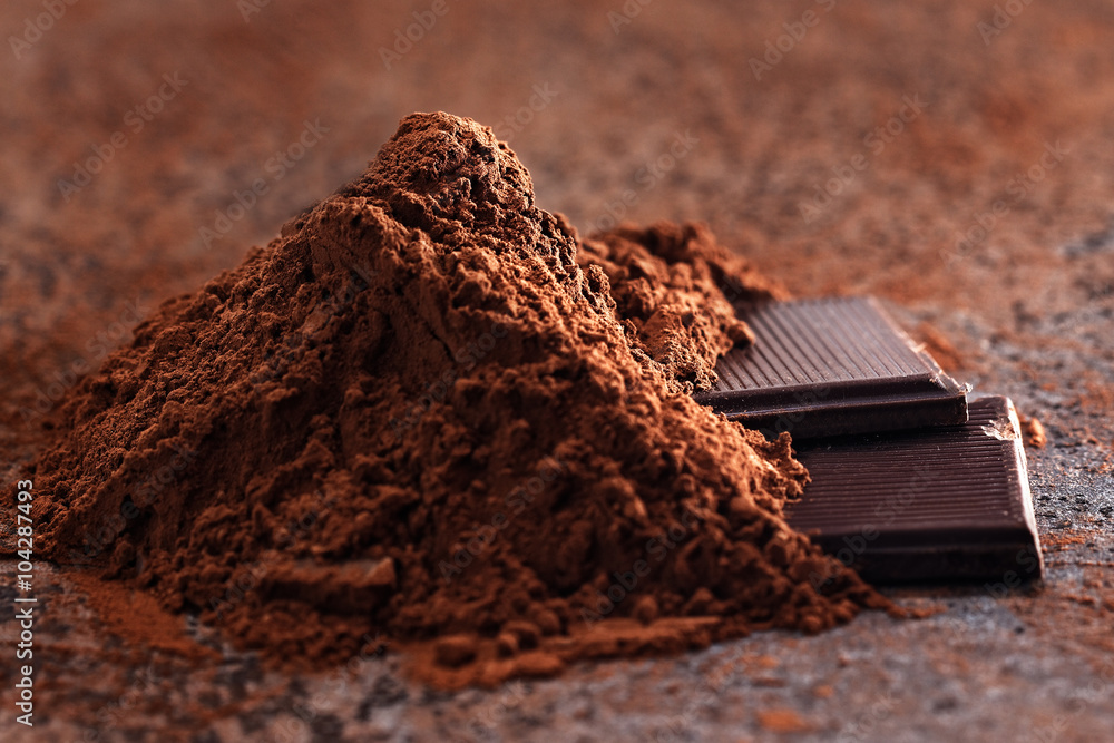 Chocolate pieces with cocoa beans on a stone table Chocolate pieces with cocoa beans on a stone table