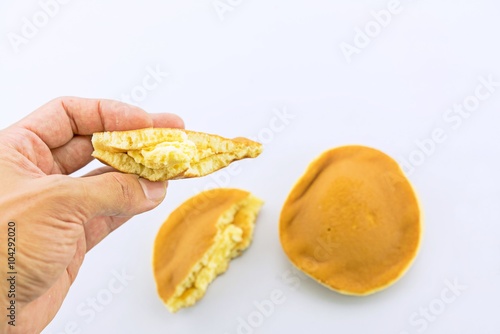 Close up of Dorayaki on hand, delicious sweets of Japanese Traditional Dessert : Dorayaki isolated on white
 photo