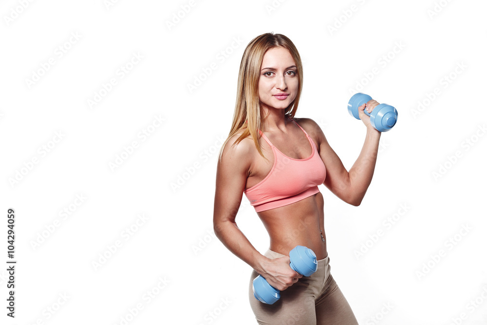 Beautiful young girl with a sports body with dumbbells on a white studio background Beautiful young girl with a sports body with dumbbells on a white studio background