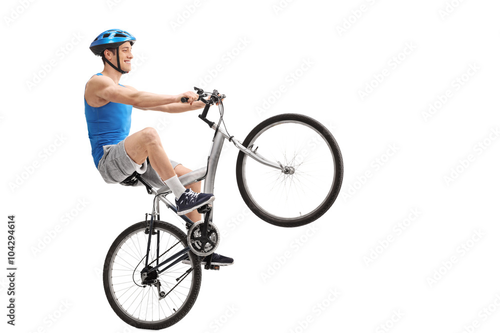 Young cyclist performing a wheelie Young cyclist performing a wheelie