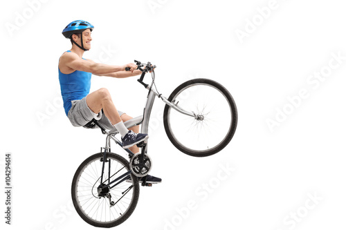 Young cyclist performing a wheelie