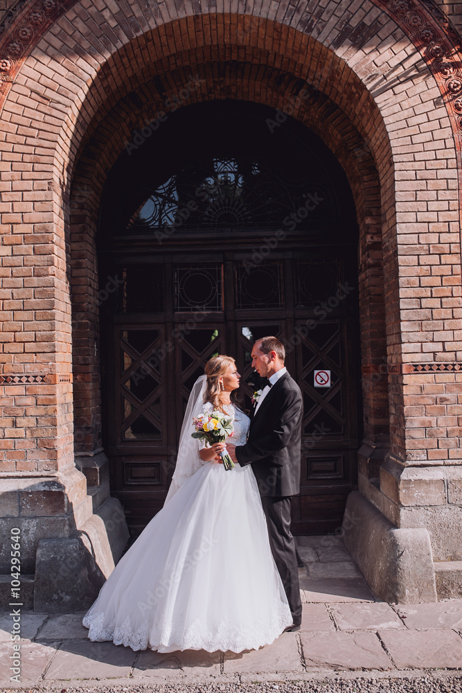 Obraz premium two couple after wedding in tne park near the castle