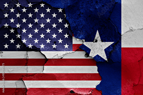 flags of USA and Texas painted on cracked wall