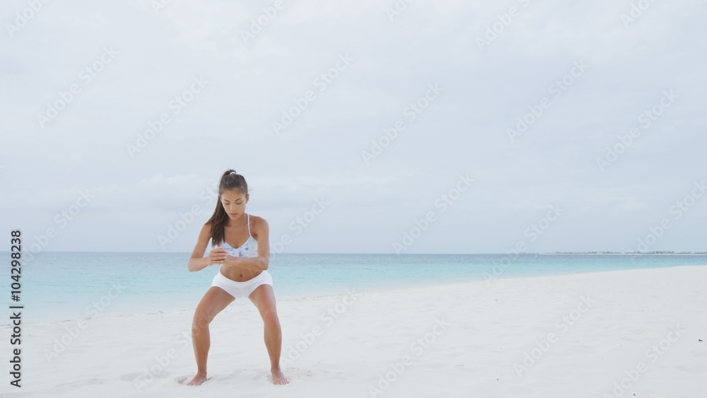 Fitness Asian woman on beach doing Pulse Squat pulses training and exercises training legs, butt, glutes and thighs as part of a full body core workout and active healthy lifestyle on beach. RED EPIC. Fitness Asian woman on beach doing Pulse Squat pulses training and exercises training legs, butt, glutes and thighs as part of a full body core workout and active healthy lifestyle on beach. RED EPIC.