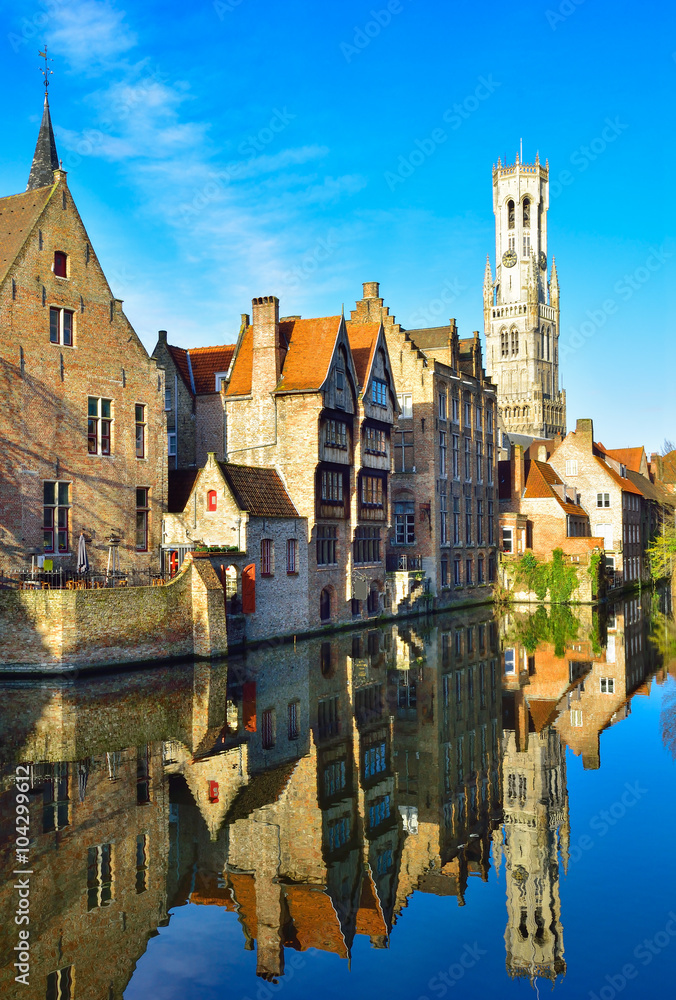 Naklejka premium Architektura Brugge wśród kanału odbite w wodzie, widok pionowy Belgii