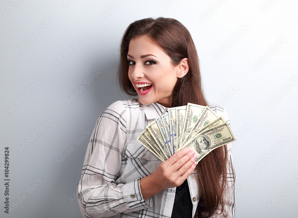 Happy successful young pretty woman holding dollars in hands wit Happy successful young pretty woman holding dollars in hands wit