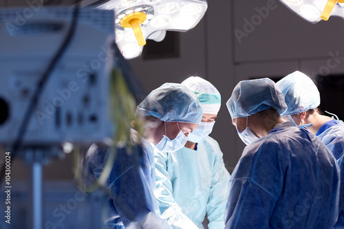 group of surgeons in operating room at hospital photo